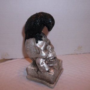 FIGURINE RAVEN SITTING ON SKELTON HEAD